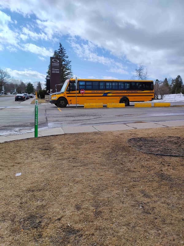Entrée du Cégep Saint-Jean-sur-Richelieu : panneau du cégep et autobus scolaire jaune